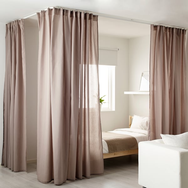 Minimalist bedroom divided by VIDGA beige curtains on track, with bed and small plant, curtains are long & wide.