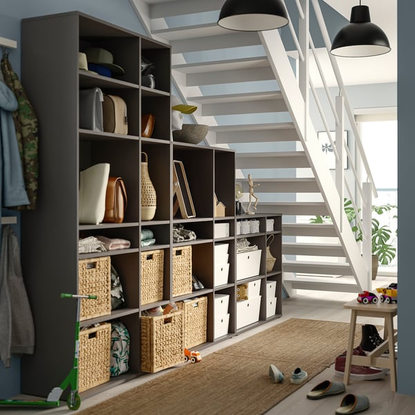 Modern storage unit VIHALS with shelves, baskets, and books. Minimalist design in black and natural colours, efficient under stairs space.