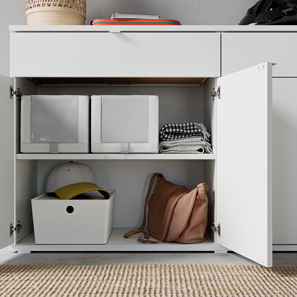 Great storage cabinet, white with two shelves, organised boxes, hat, and bag.