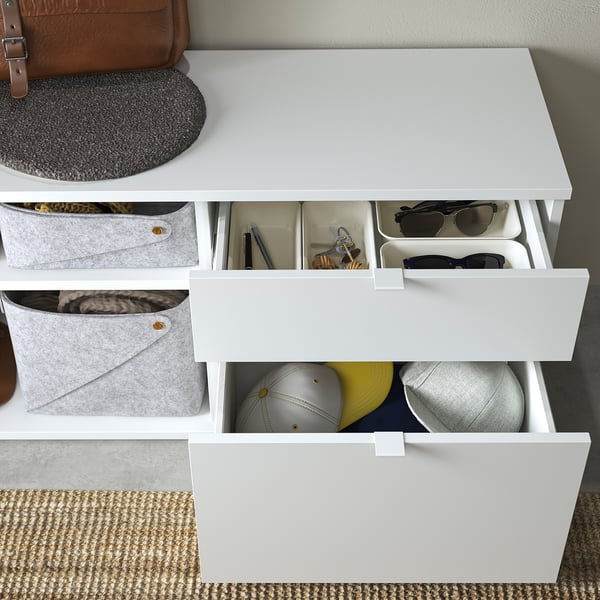 White VIHALS storage bench with open and closed compartments, organising various items.