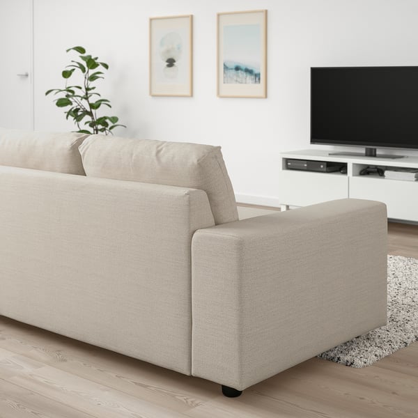 Modern living room with beige VIMLE sofa-bed, tv, art frames. Sofa fits well in room, comfortable and versatile.