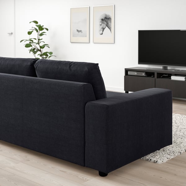 Modern black VIMLE sofa in minimalist living room with tv, rug, and decor.