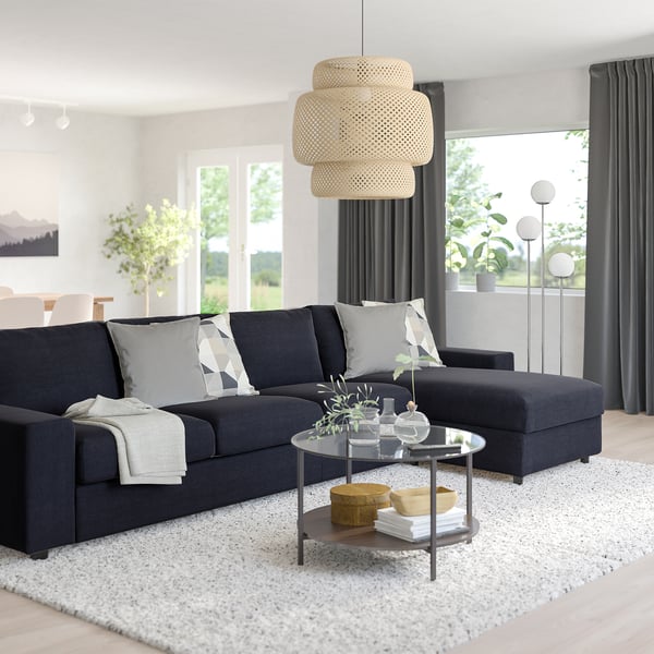 Modern living room with dark grey VIMLE sofa, black coffee table, and large floor lamp. Sleek design, large rug, minimalist decor.