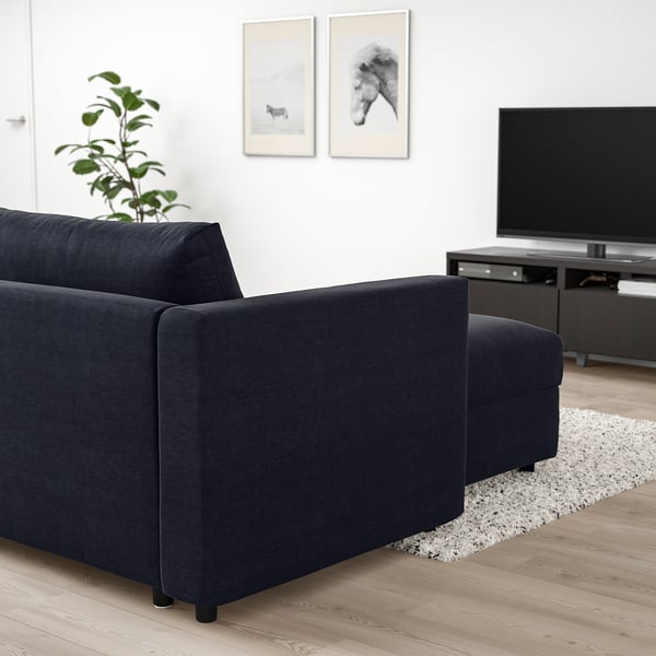 Modern living room with VIMLE dark grey sofa, tv, and plant. Sofas dark colour contrasts with light floor and wall, displaying its boxy, sleek design.
