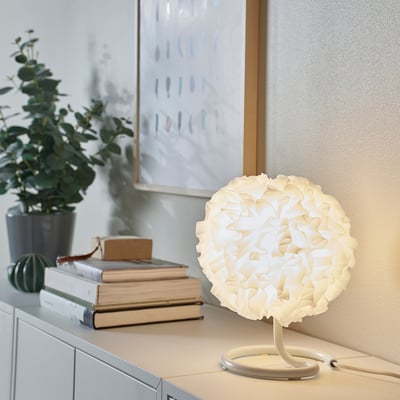 White eco-friendly VINDKAST lamp beside books, small, round, modern design.