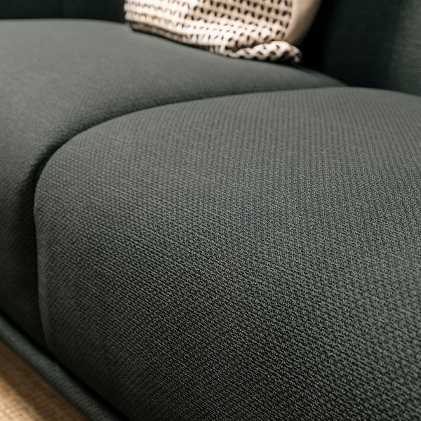 Dark green textured fabric sofa, deep seat, inviting shape.