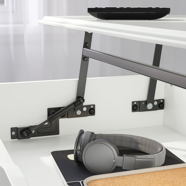 Desk with adjustable height, holding keyboard above and headphones below.