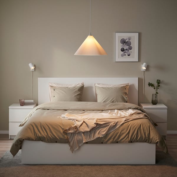 Modern bedroom with ZEBRASÄV lamp over beige bed.