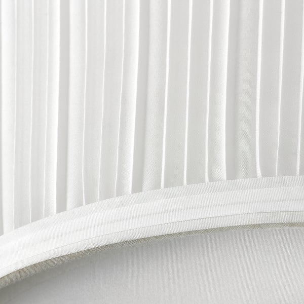 Elegantne valge kaasaegne pehme hajutusvarjuga lamp, mis kiirgab õrna valgust.