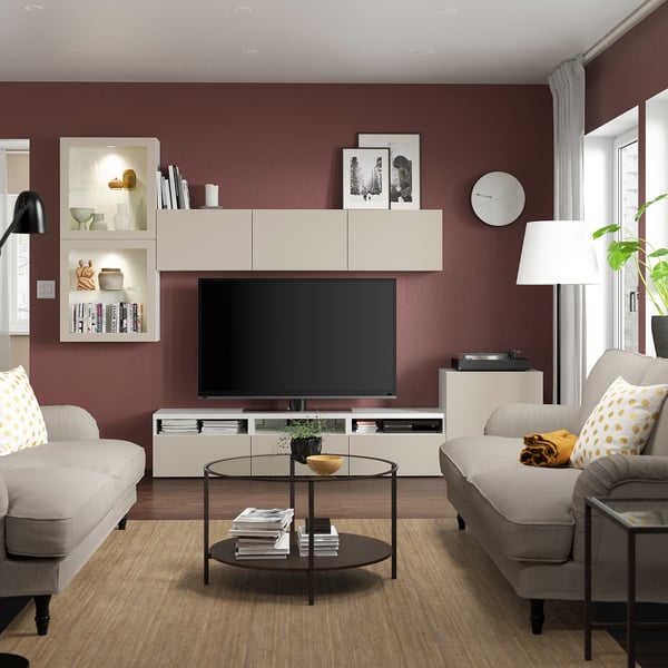 Elutuba hallide diivanite, kollaste patjade, musta diivanilaua, valge televiisori, Burgundia seinte, dekoratiivkappide, suure akna ja moodsa lambiga.