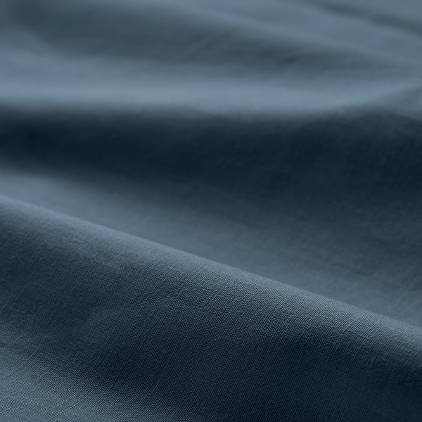 Pehme, kortsus sinakashall puuvillane kangas lähivõte, mis näitab sileda tekstuuri ja kvaliteeti.