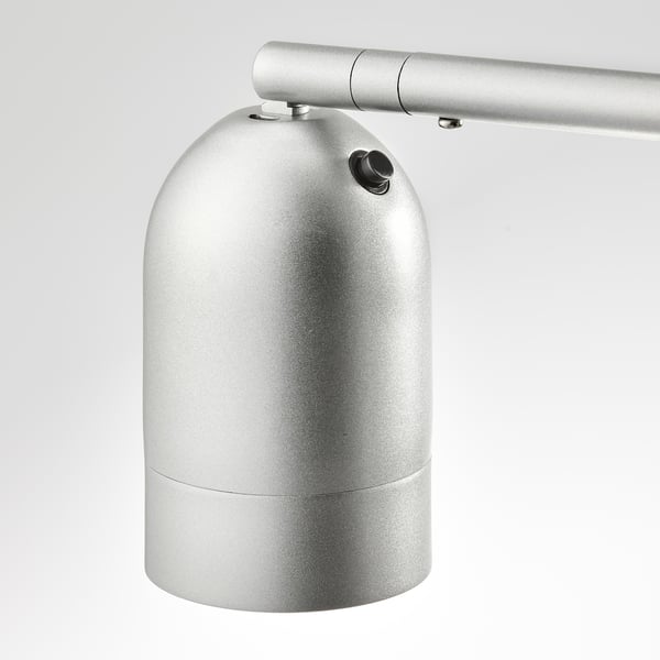 Hõbedane kaasaegne lamp reguleeritava käe ja silindrilise varjundiga. Kvaliteetne metallikviimistlus, vastupidav disain.