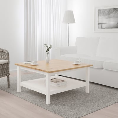 HEMNES naturaalne männi- ja valge diivanilaud koos hoiuriiuliga elutoas.