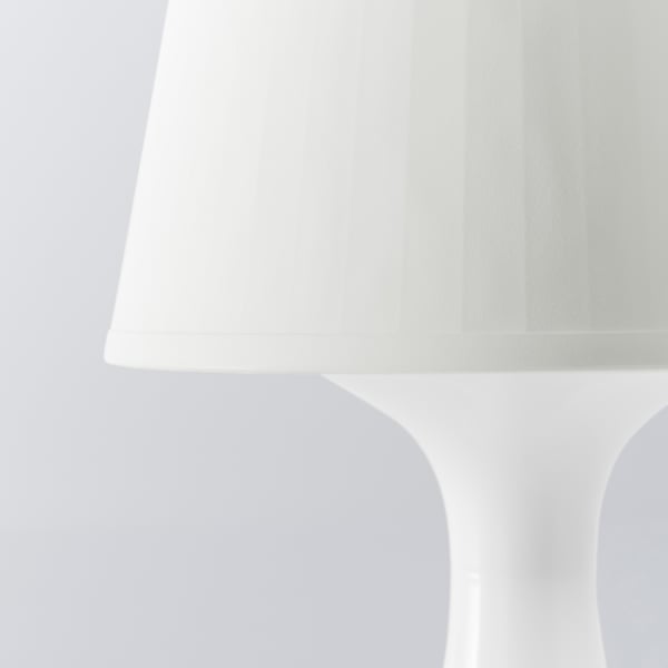 Kaasaegne valge lamp klanitud, kumera disainiga. Minimalistlik stiil, mis sobib ideaalselt kaasaegsesse sisekujundusse.