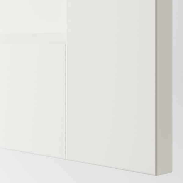 Elegantne ja kaasaegne valge kapp, millel on siledate pindade ja ühe vertikaalse joonega, mis rõhutab minimalistlikku disaini.