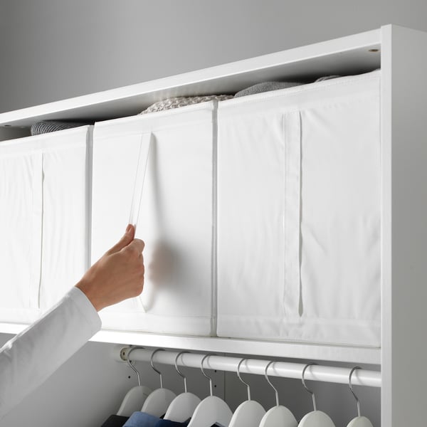 Inimene, kes korraldab SKUBB hoiukaste kapis, tuues esile käepidemega kasti funktsionaalse omaduse.