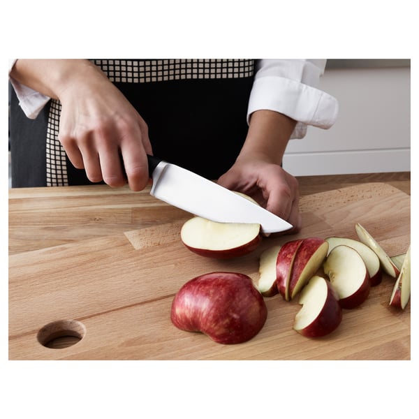 Inimene viilutab õunu hõbedase noaga puitplaadile.