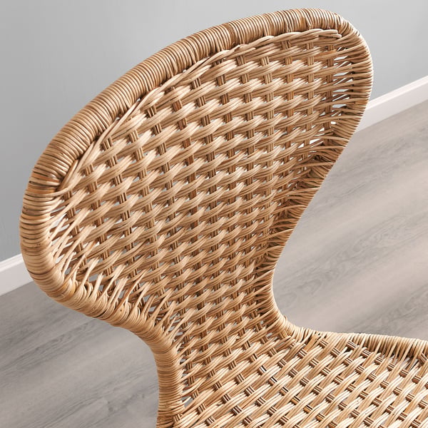 Wicker chair detail, handwoven rattan, supportive curved seat/back, natural finish.