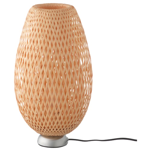 A BÖJA lamp with a woven bamboo shade and a metal base, casting intricate light patterns.