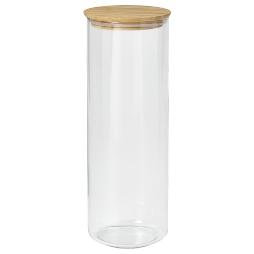A clear glass jar named EKLATANT with a wooden lid. It is cylindrical, suitable for storing food, and has a simple, elegant design.