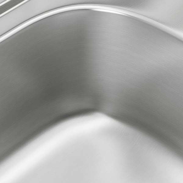 Stainless steel sink close-up showing smooth, polished surface reflecting light, highlighting its durability and hygiene qualities.