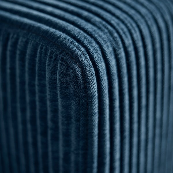 Close-up of plush, deep blue, ribbed sofa cushions, showcasing soft, high-quality fabric and detailed stitching.