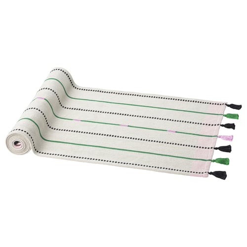 A MÄVINN white cotton runner with green and pink stripes, hand-tied tassels, rectangular shape.