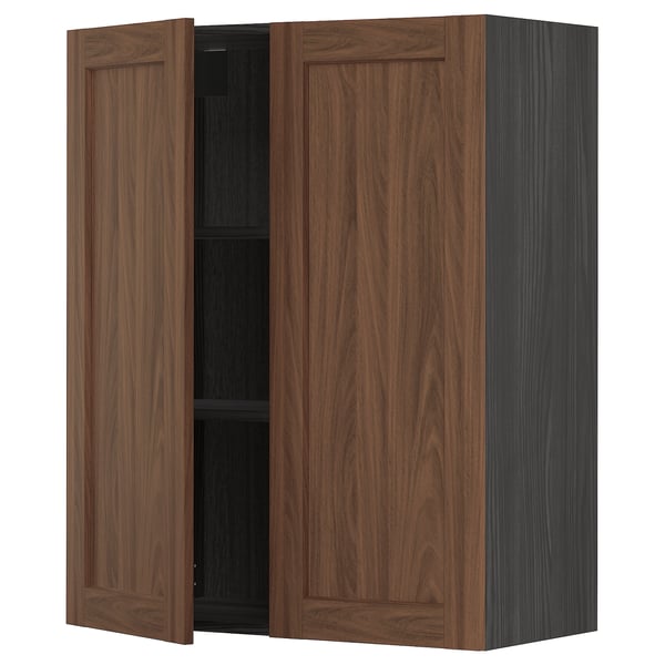 An ikea METOD kitchen cabinet with walnut finish. It two wooden doors, with one open revealing a black interior and a shelf.