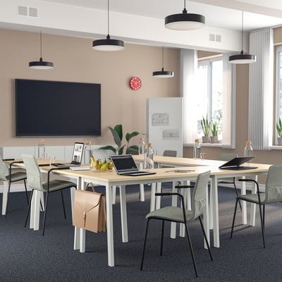 Modern office with MITTZON tables, chairs, & red clock - u-shape setup for meetings.