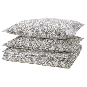 Stack of beige paisley pillowcases with floral designs.