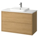 Tocador de bany modern de roure clar amb taulell de marbre blanc i lavabo.