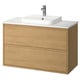 Tocador de bany modern de roure clar amb taulell de marbre blanc i lavabo.