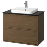 Tocador de bany modern de fusta de roure marró amb taulell negre i lavabo quadrat blanc. De paret amb disseny minimalista.