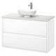 Tocador de bany modern de paret blanc amb acabat llis, dos calaixos i lavabo rodó de marbre.