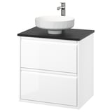 Tocador de bany modern de paret blanc amb taulell negre elegant i lavabo blanc rodó.