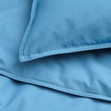 Fundes nòrdiques i de coixí blau clar plegades perfectament, mostrant un material de cotó llis i suau.