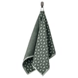 Una tovallola penjant de color gris verdós amb un patró triangular i felp per un costat.