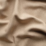 Primer pla de cortines de tela beix, que mostren una textura densa i material de qualitat.