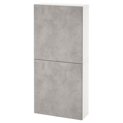Un moble de paret BESTÅ blanc i gris amb dues portes en acabat de formigó, dissenyat per a l'emmagatzematge.