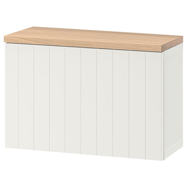 Moble d'emmagatzematge BESTÅ blanc amb tapa de roure, forma rectangular, ranures verticals.