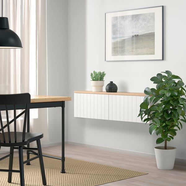 Decoració moderna amb plantes grans, art emmarcat i magatzem BESTÅ sota una finestra. ”