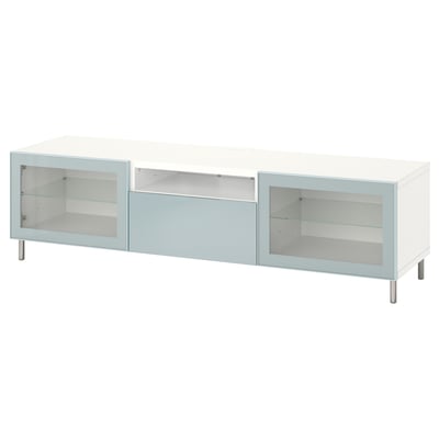 Un banc de TV BESTÅ blanc amb portes de vidre blau clar i potes metàl·liques, amb compartiments d'emmagatzematge oberts.