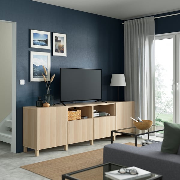 Sala d'estar moderna amb tv, sofà i catifa. Llum natural a través de cortines.