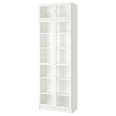 Una prestatgeria blanca ikea BILLY amb portes de vidre, alta i rectangular, amb prestatges regulables.