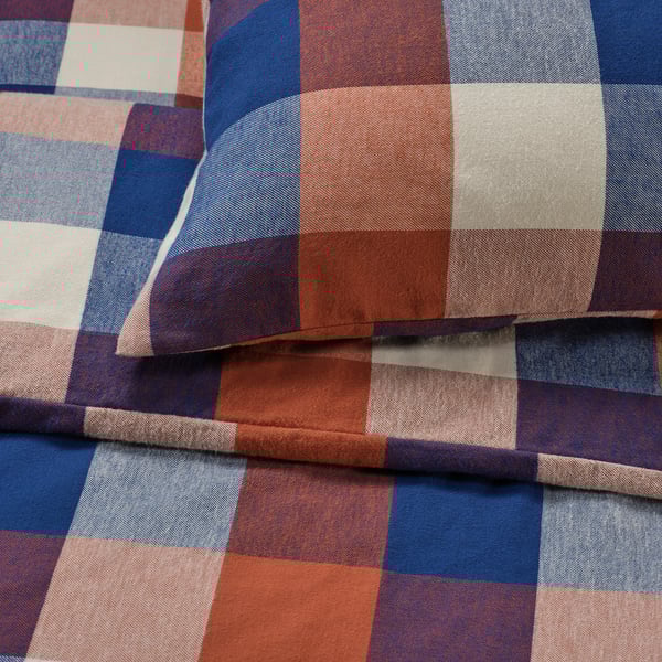 Teixit de franela a quadres, multicolor en blau, vermell i blanc, plegat perfectament mostrant la seva textura suau i càlida.