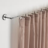 Vareta de cortina amb cortines beix, fixada a la paret amb accessoris regulables.