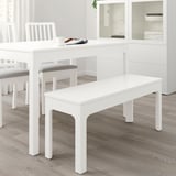 Banc EKEDALEN blanc al costat de la taula de menjador amb cadires.