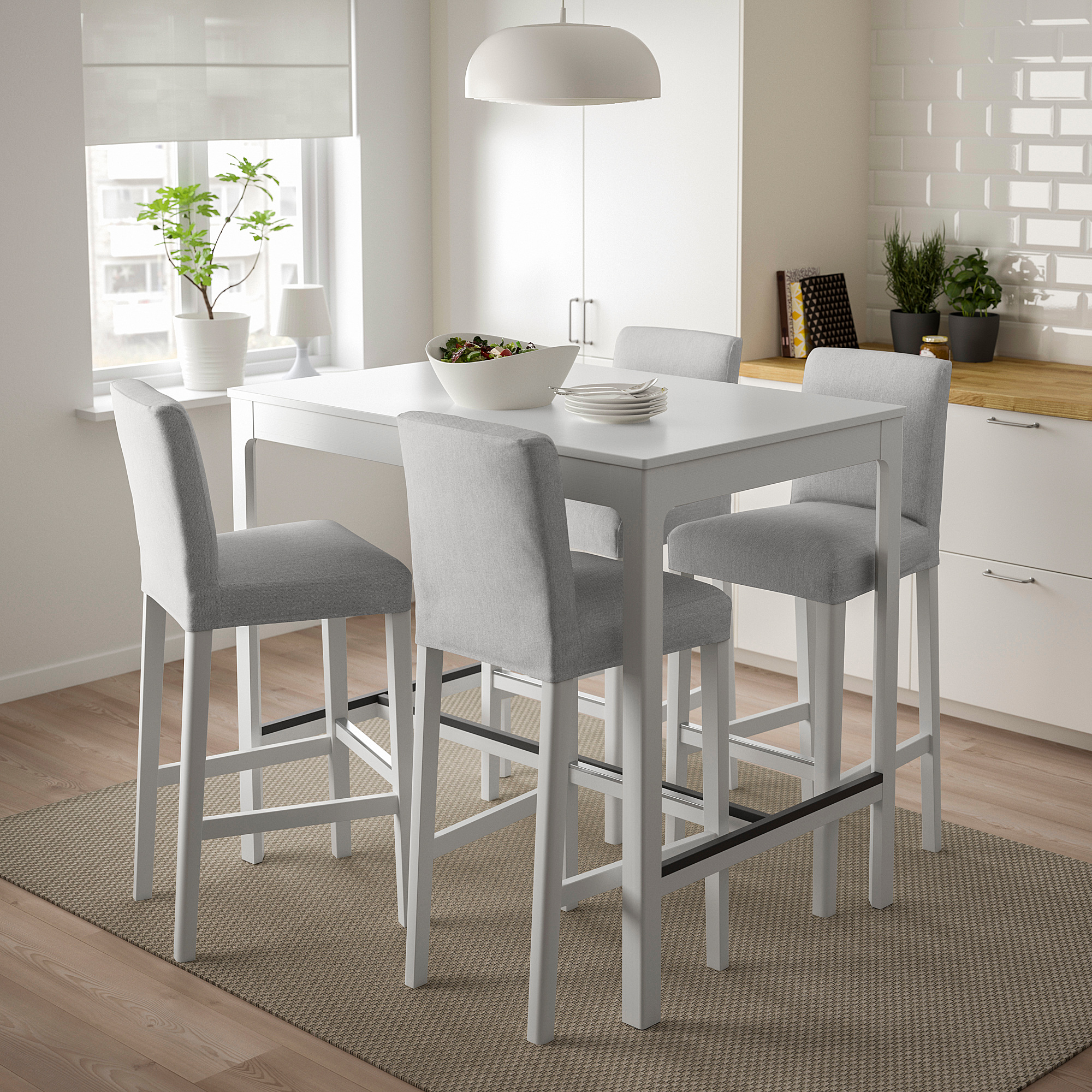 Conjunt de menjador modern amb taula quadrada blanca i quatre tamborets de bar coixinats grisos, adequat per a espais compactes, disseny lluminós i minimalista.
