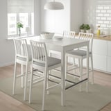 Taula de bar EKEDALEN blanca amb quatre tamborets, seients encoixinats i un disseny modern.