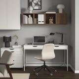 Oficina moderna a casa amb emmagatzematge EKET, escriptori, cadira, llums, detalls de fusta.